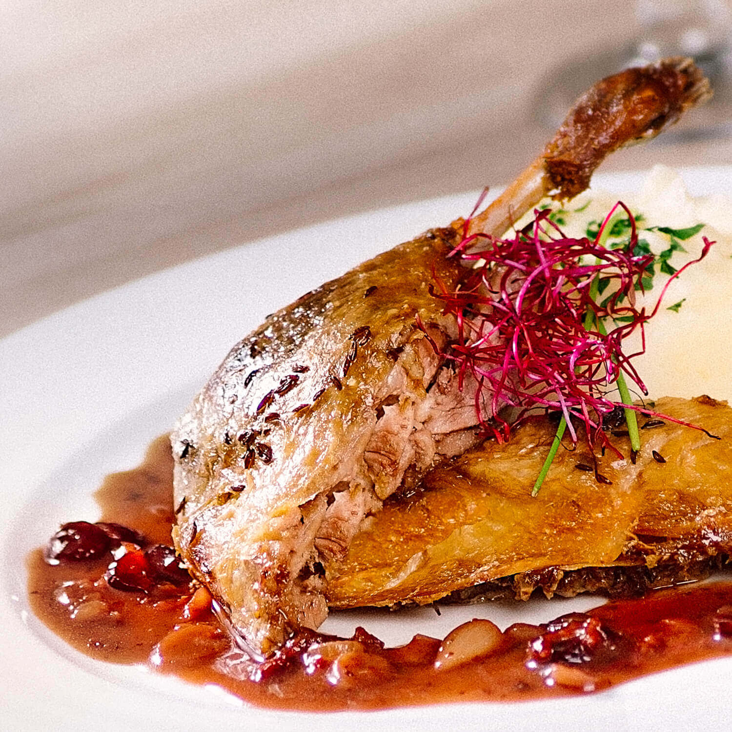 Kačacie stehno s omáčkou z čierneho piva a brusníc so zemiakovým pyré